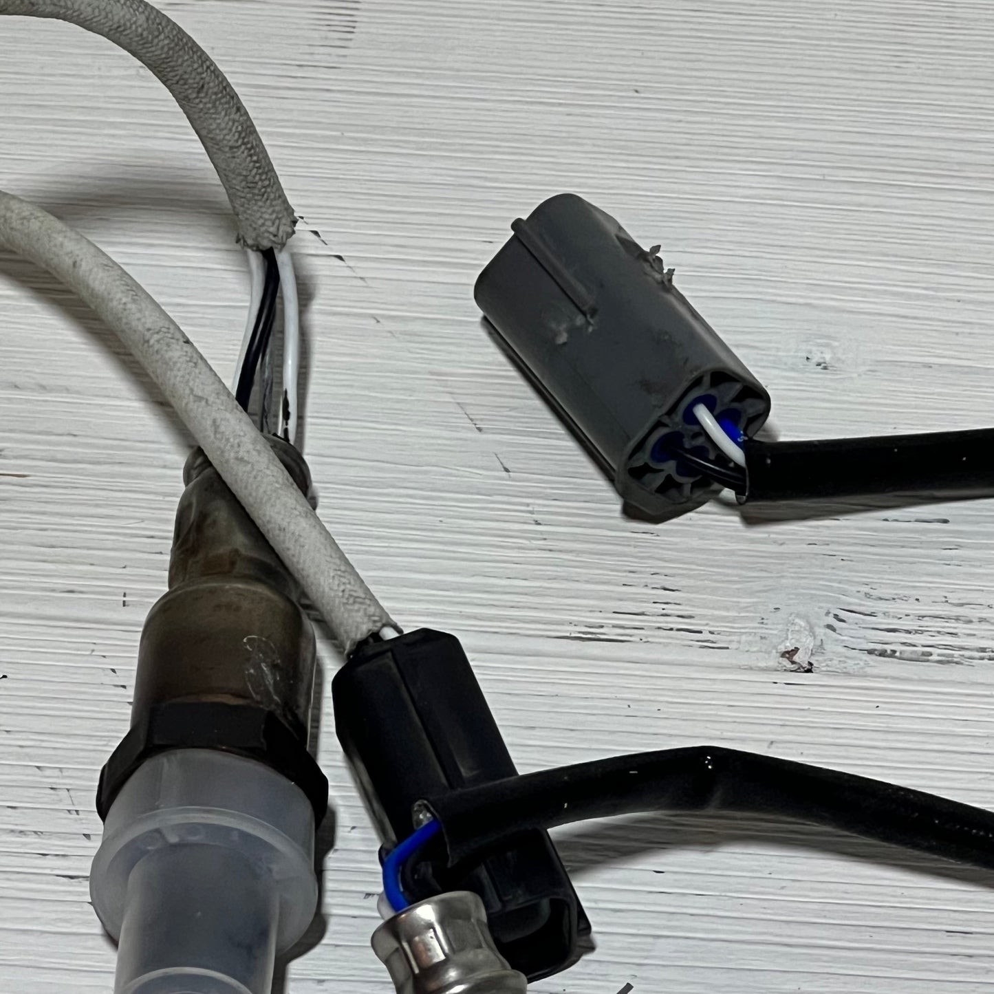 Upstream and downstream oxygen sensors for Nissan Rogue 2.5L, showcasing connectors and wiring on a white background.