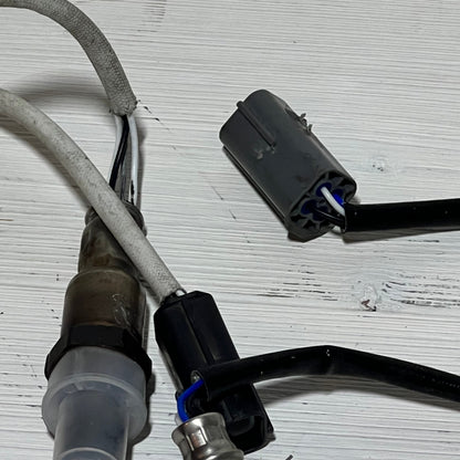 Upstream and downstream oxygen sensors for Nissan Rogue 2.5L, showcasing connectors and wiring on a white background.