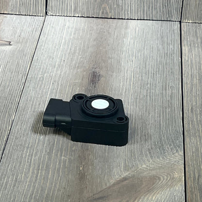 Black TPS Throttle Position Sensor Kit for Ford and Volvo trucks, model 1045796680-134143, on wooden surface.