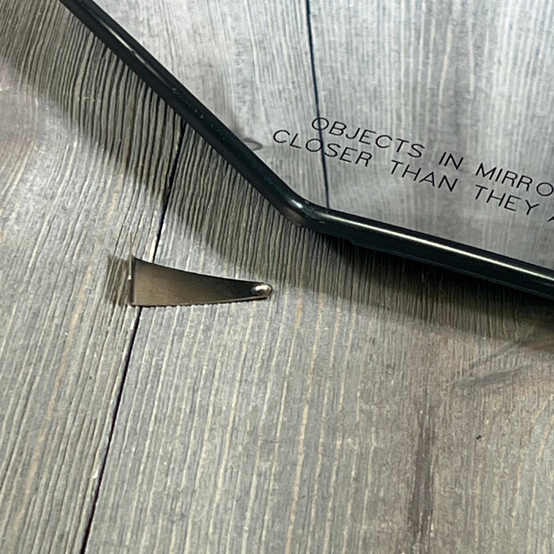 Passenger side heated mirror glass with plastic backing, featuring "objects closer" text for enhanced safety.