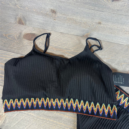 Black ribbed bikini top with colorful zigzag trim on a wooden background, part of the Lilosy set in XXL.