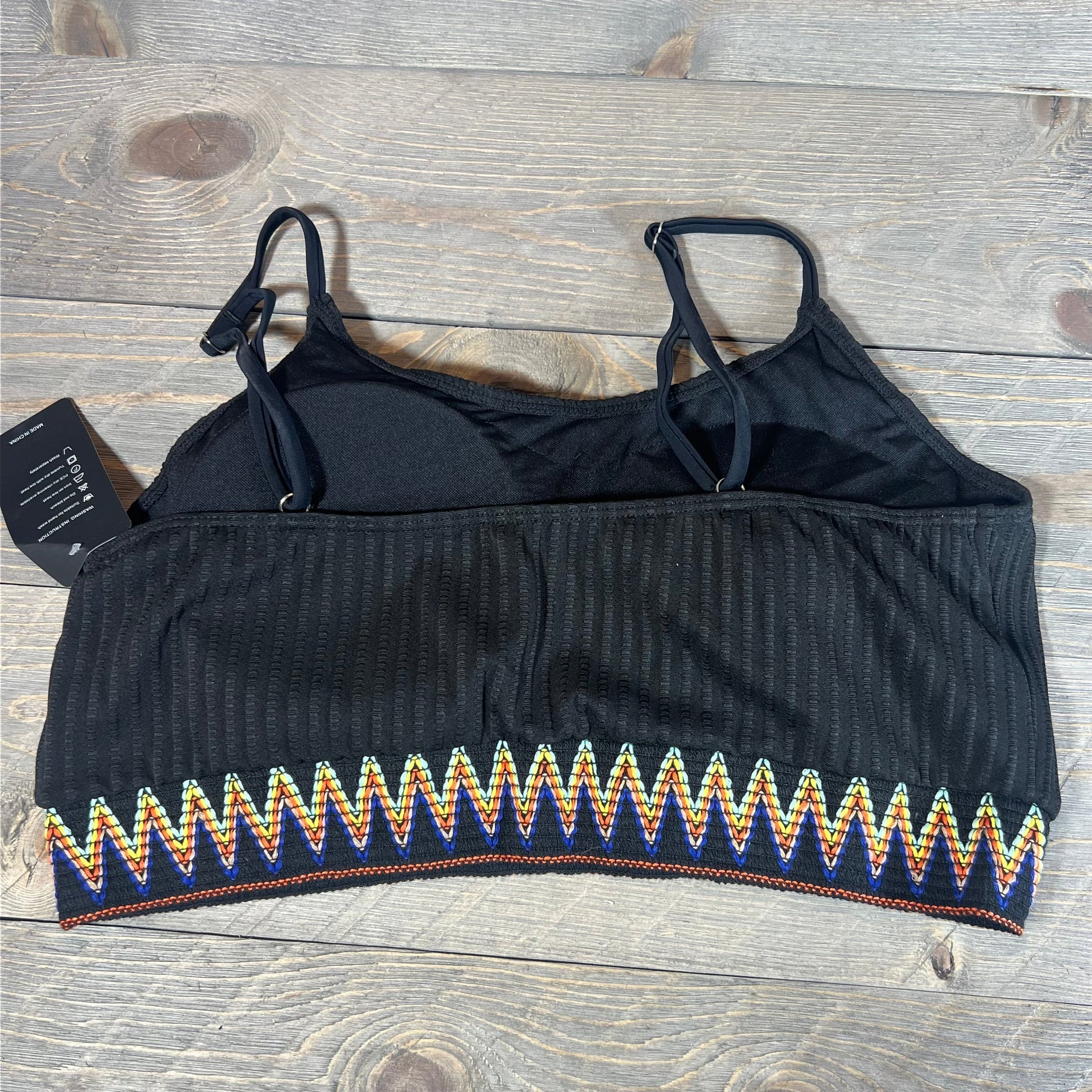 Black ribbed crop top with colorful zigzag trim from Lilosy High Waisted Bikini Set, size XXL, on wooden background.