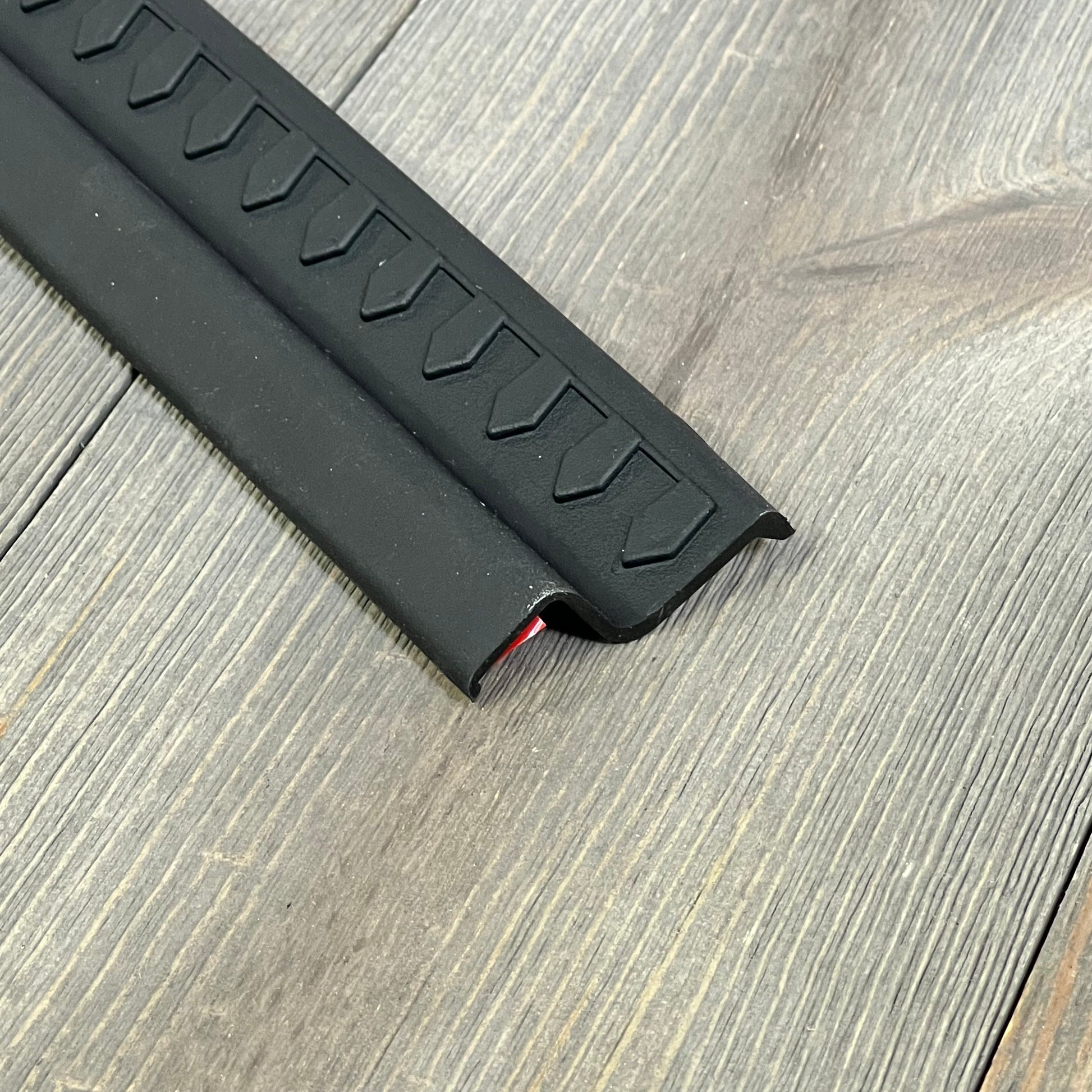 Black thermoplastic entry guard for Jeep Wrangler TJ/LJ, textured design, no-drill installation, durable protection.
