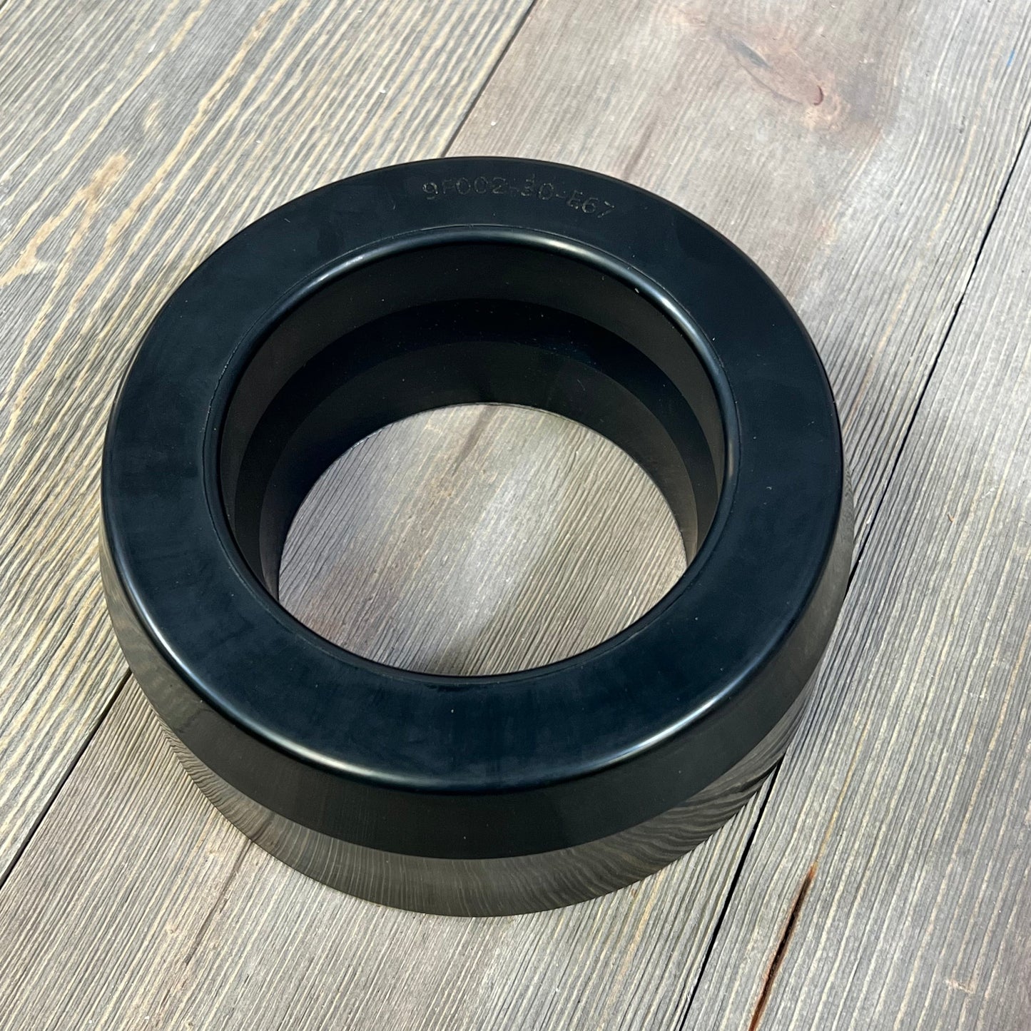 Polyurethane coil spring strut spacer for 1999-2006 Chevy Silverado 1500 and GMC Sierra 1500, enhancing front lift.
