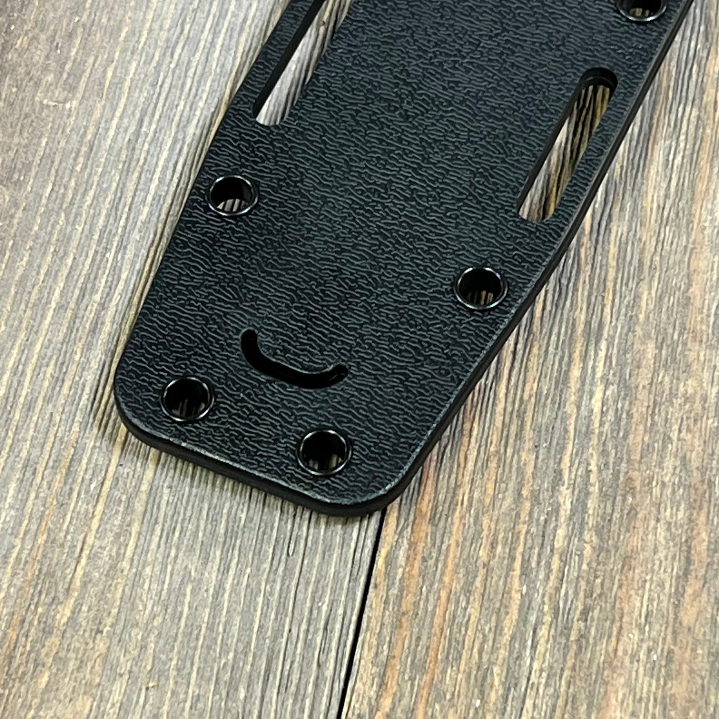 Black Ka-Bar Kydex sheath close-up, showing textured surface and mounting holes, designed for short knives.