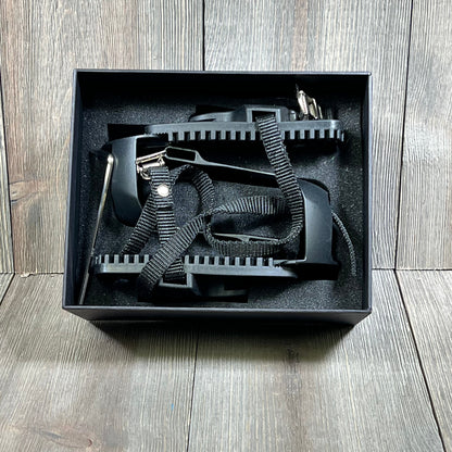 Black Kelecuia toe cages for Peloton bike in box, featuring durable straps and adapters for converting to toe clip pedals.
