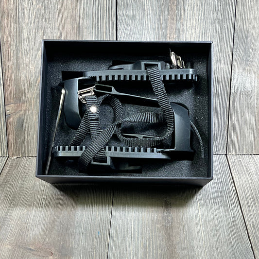 Black Kelecuia toe cages for Peloton bike in box, featuring durable straps and adapters for converting to toe clip pedals.