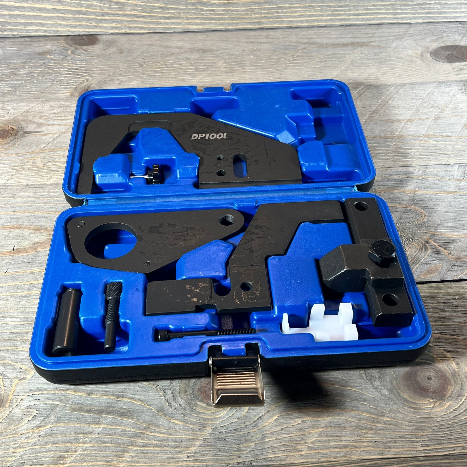 Blue case with DPTOOL camshaft timing lock tool set for Ford/Jaguar engines on wooden background.