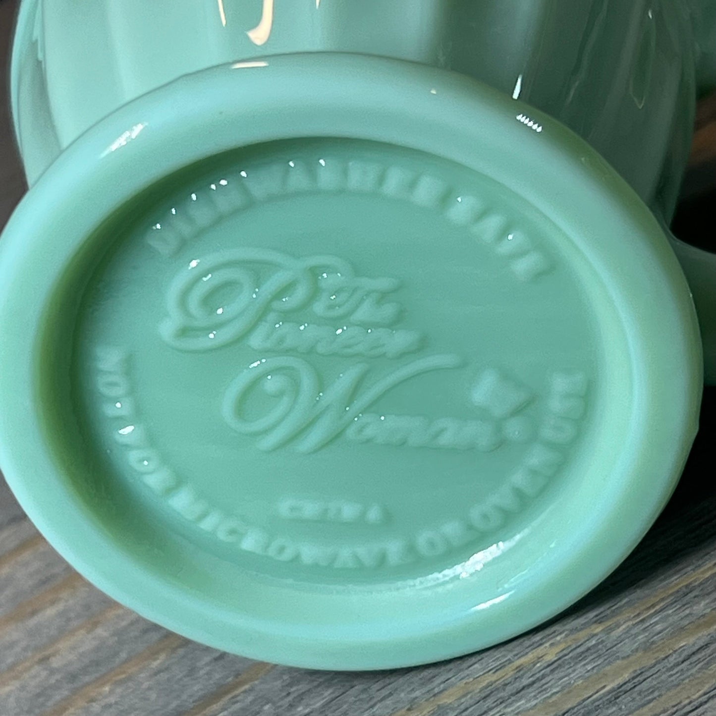 Bottom view of The Pioneer Woman Timeless Beauty Jade Creamer showcasing embossed brand details and smooth finish.