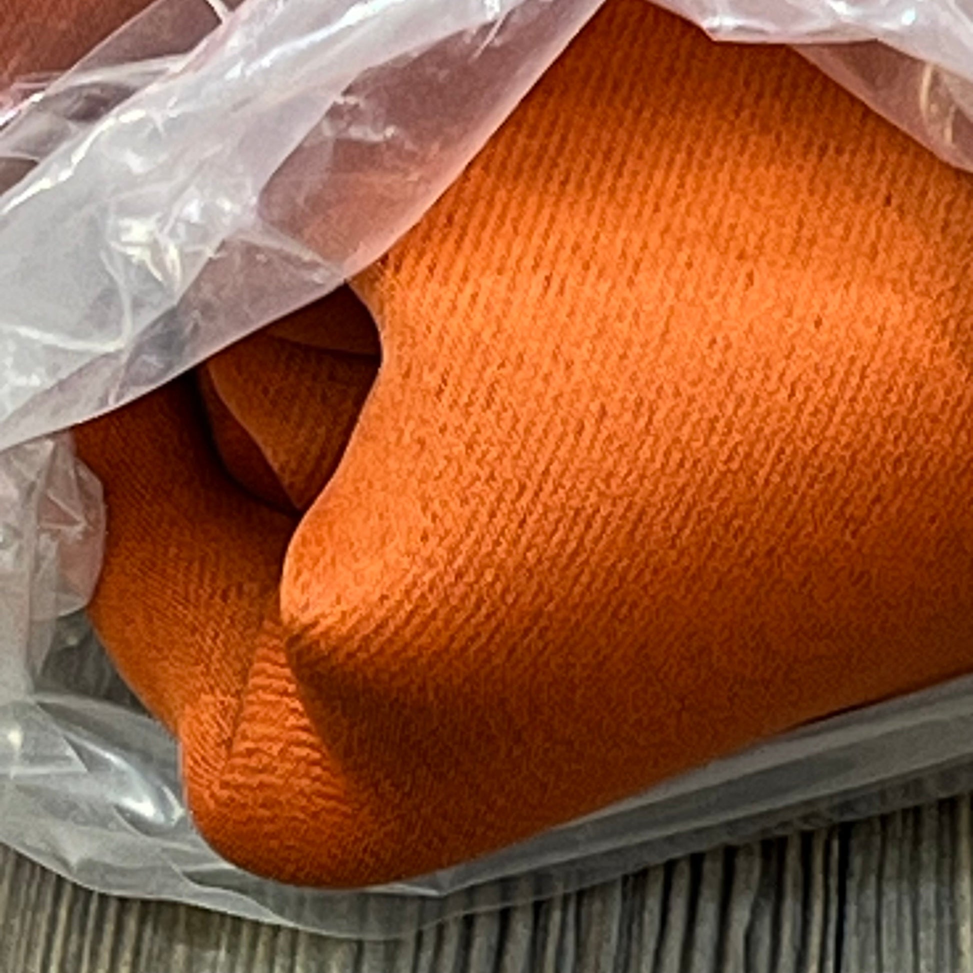 Burnt orange blackout curtains tightly rolled, showcasing texture and quality fabric for bedroom privacy and light control.