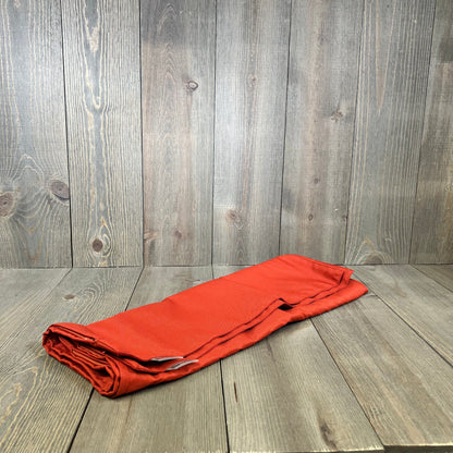 Burnt brick pillow cover folded on wooden surface, showcasing durable fabric for outdoor use, perfect for garden decor.