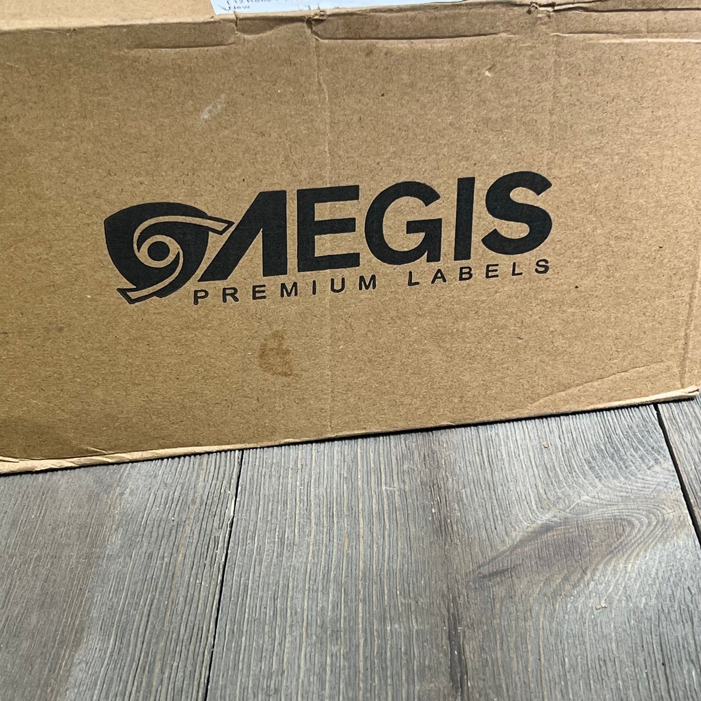 Aegis Adhesives packaging for Brother DK-1209 label replacement, featuring 12 rolls plus frame for QL label printers.