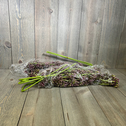 Faux plum sedum berry stems wrapped in plastic on a wooden surface, perfect for autumn and Thanksgiving décor.