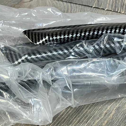 Carbon fiber car fender flares in packaging, showcasing flexible design for universal wheel arch protection.
