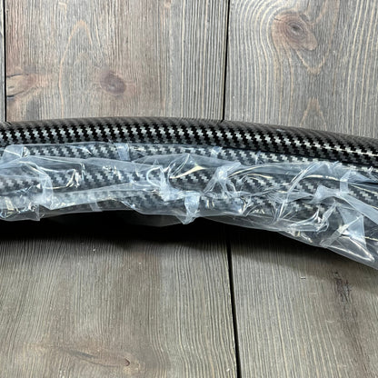 Carbon fiber DREAMIZER 2" car fender flares wrapped in protective plastic, ready for installation on vehicle wheel arches.