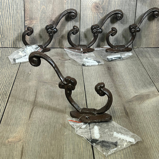 Set of four rustic brown cast iron hooks, perfect for farmhouse decor. Ideal for hanging coats, bags, and towels.