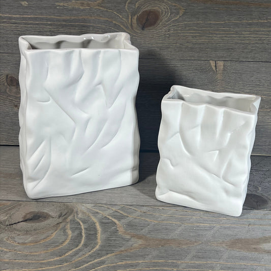 Ceramic vase set with crinkle paper bag design in crème and coconut café finish on rustic wood background.
