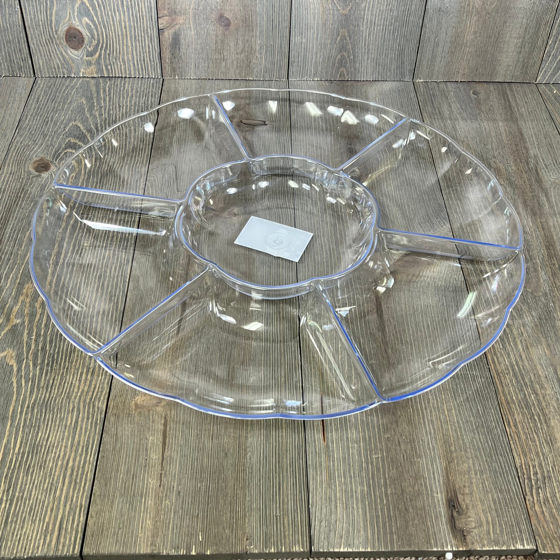 Clear round serving tray with seven sections, ideal for parties. Durable hard plastic, perfect for elegant food presentation.