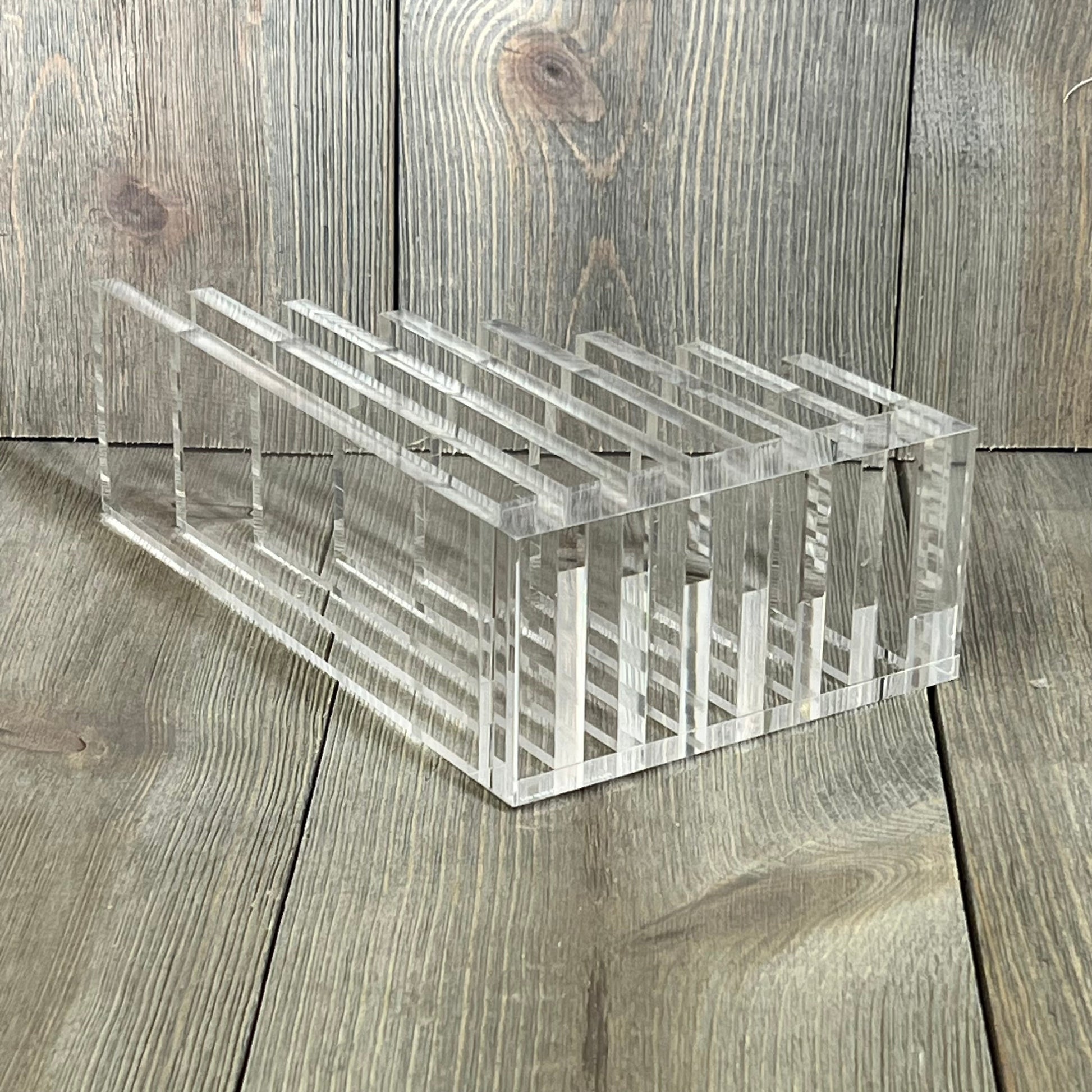 Clear acrylic collator and bookend, 5” x 8” x 2.5”, on wooden surface, ideal for organizing books and documents.