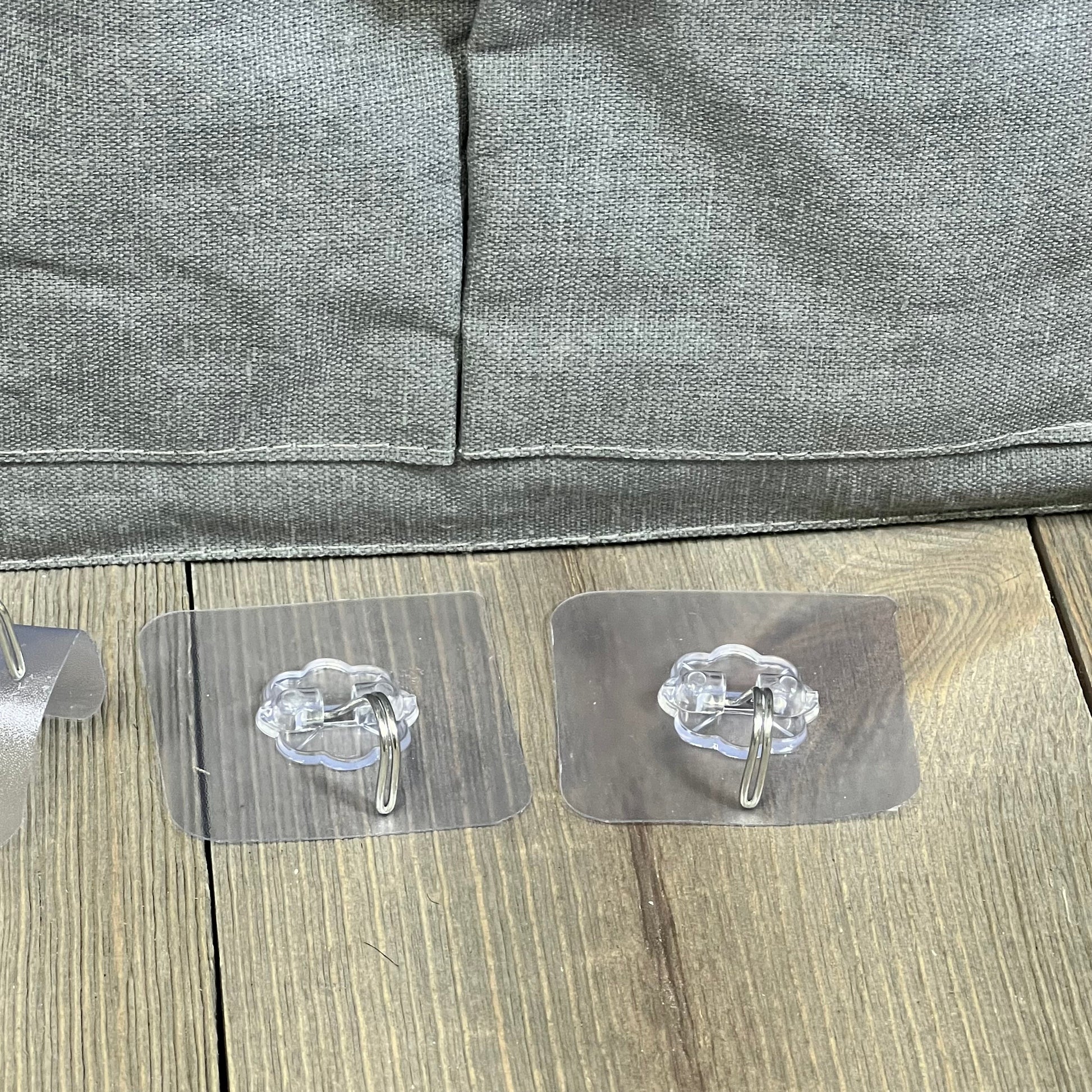 Gray wall hanging organizer bag with clear adhesive hooks, perfect for kitchen or bedroom storage solutions.