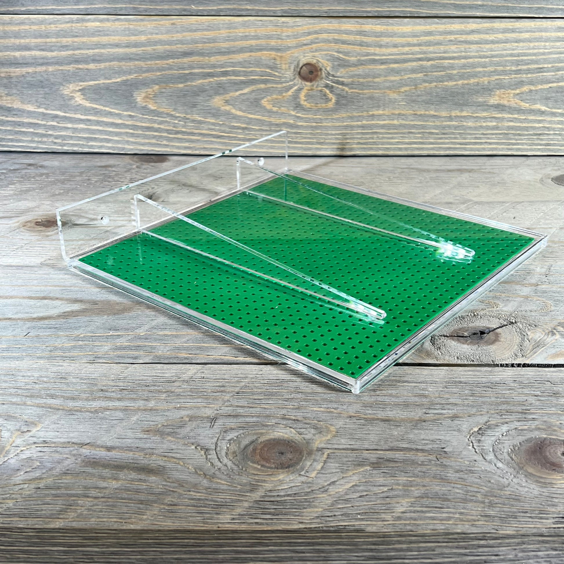 Clear acrylic wall mount shelf with green base for minifigures, compatible with major brick brands, 10x10 inches.