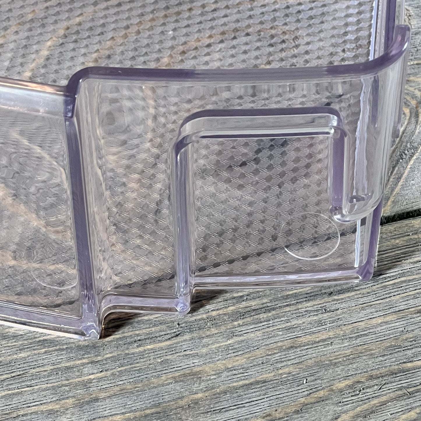 Clear plastic refrigerator door shelf bin MAN63948502 for LG and Kenmore, close-up view on wooden surface.