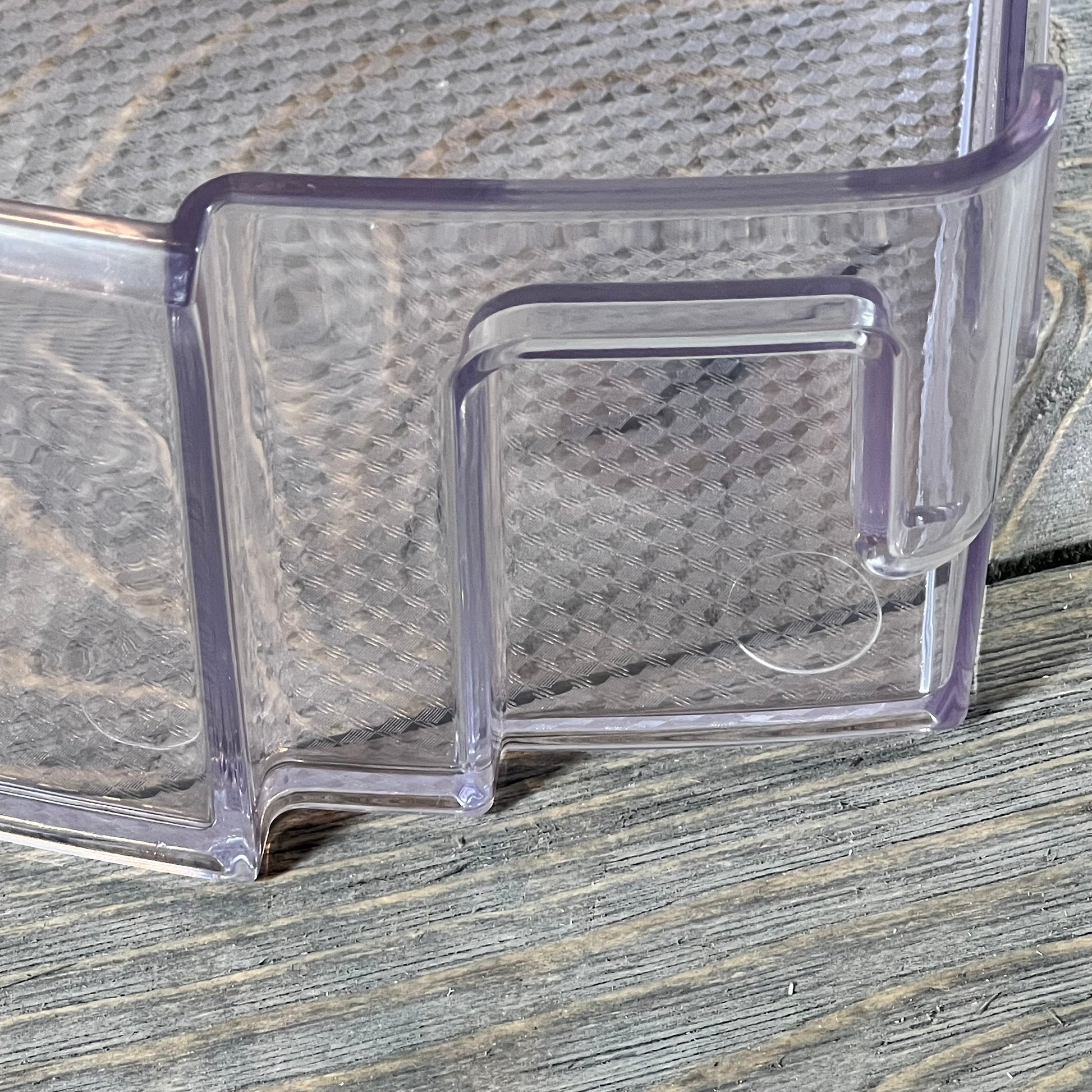 Clear plastic refrigerator door shelf bin MAN63948502 for LG and Kenmore, close-up view on wooden surface.