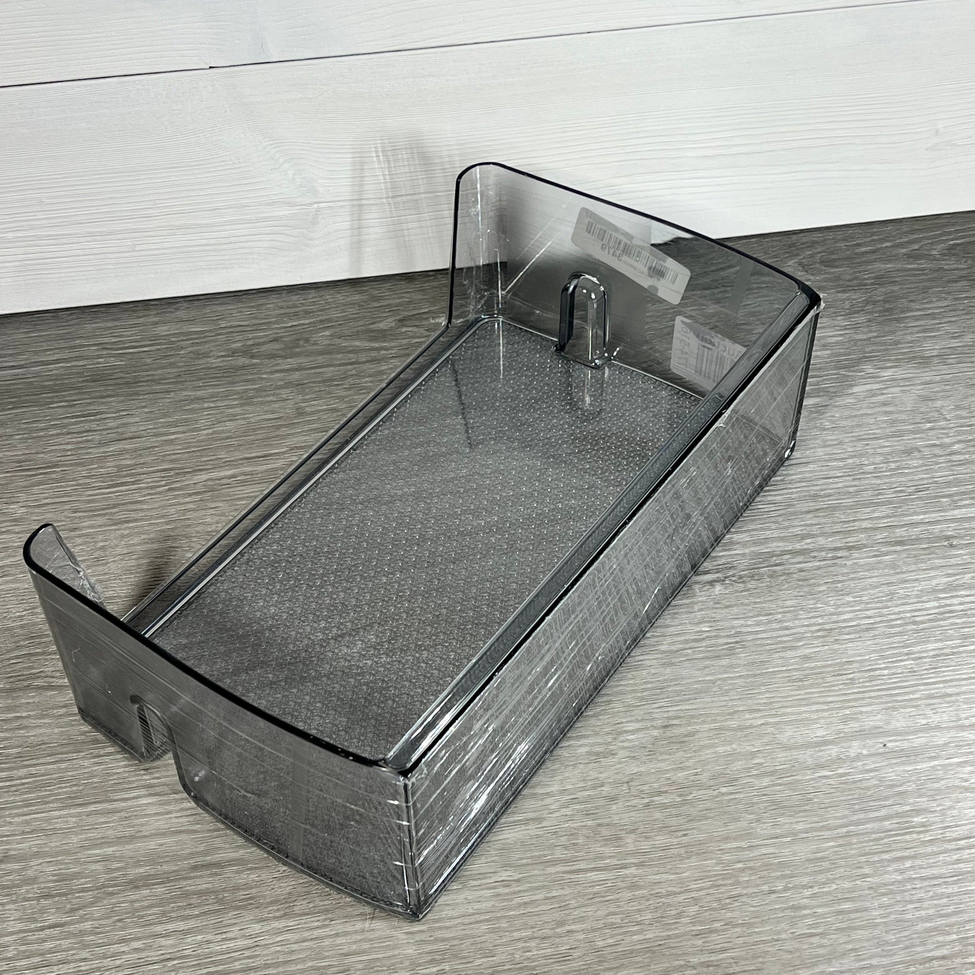 Clear Samsung compatible refrigerator door shelf bin replacement on wooden surface.