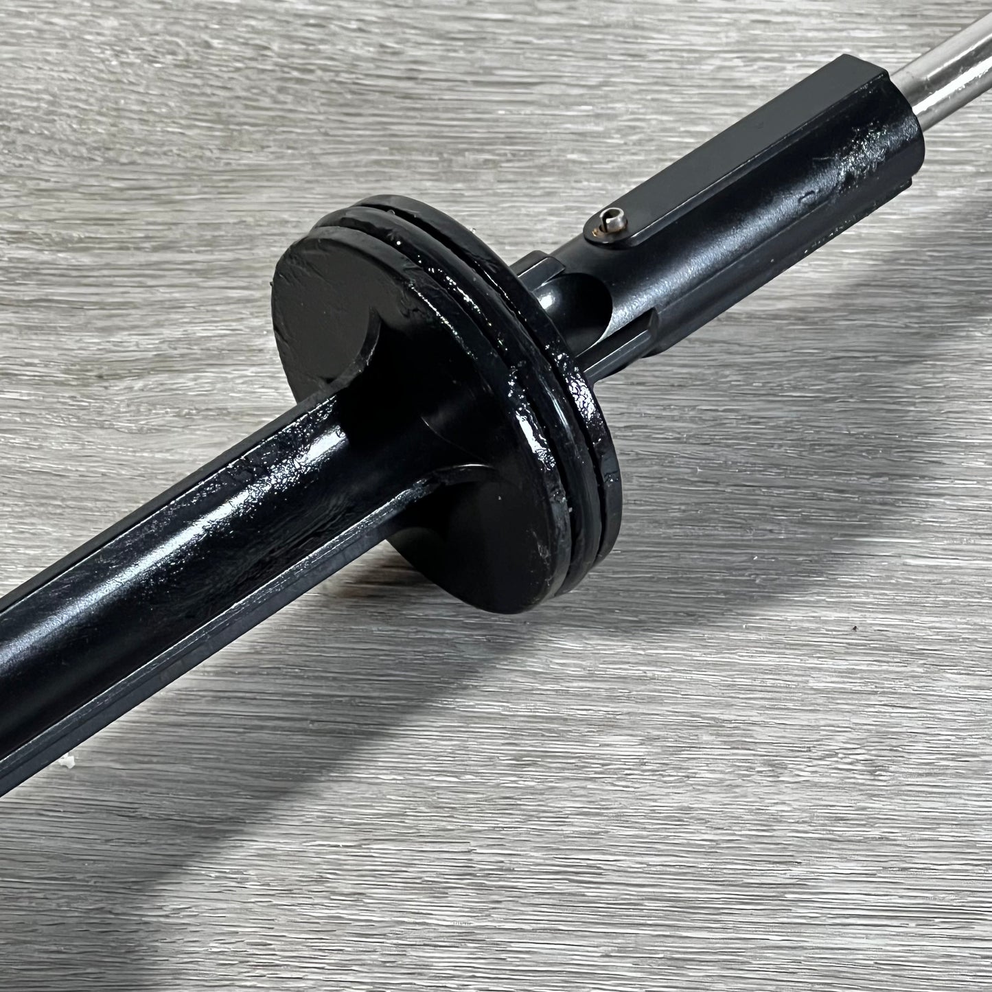Close-up of 1045743403-GUOJINJISM handle and piston assembly showing sleek black finish on gray surface.