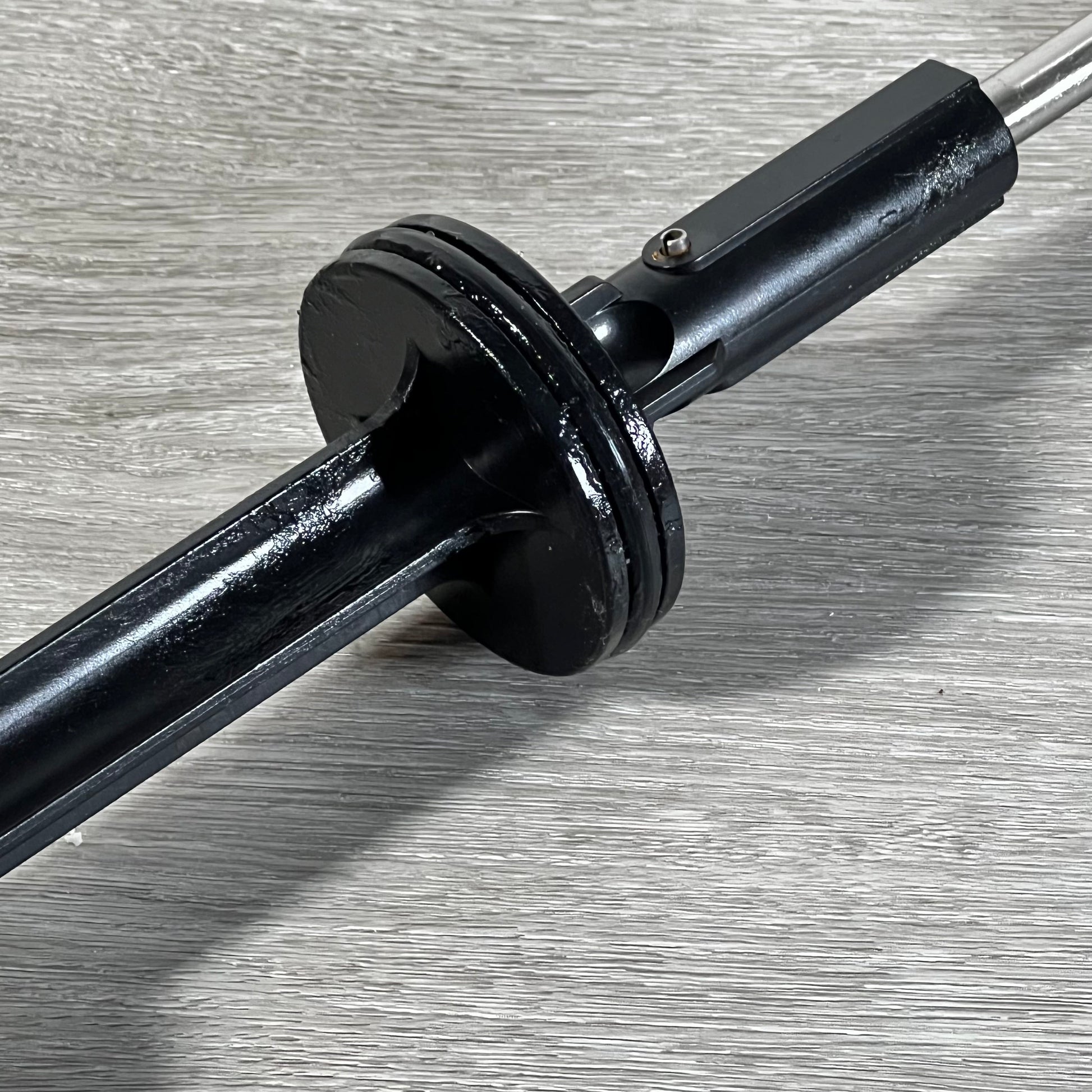 Close-up of 1045743403-GUOJINJISM handle and piston assembly showing sleek black finish on gray surface.
