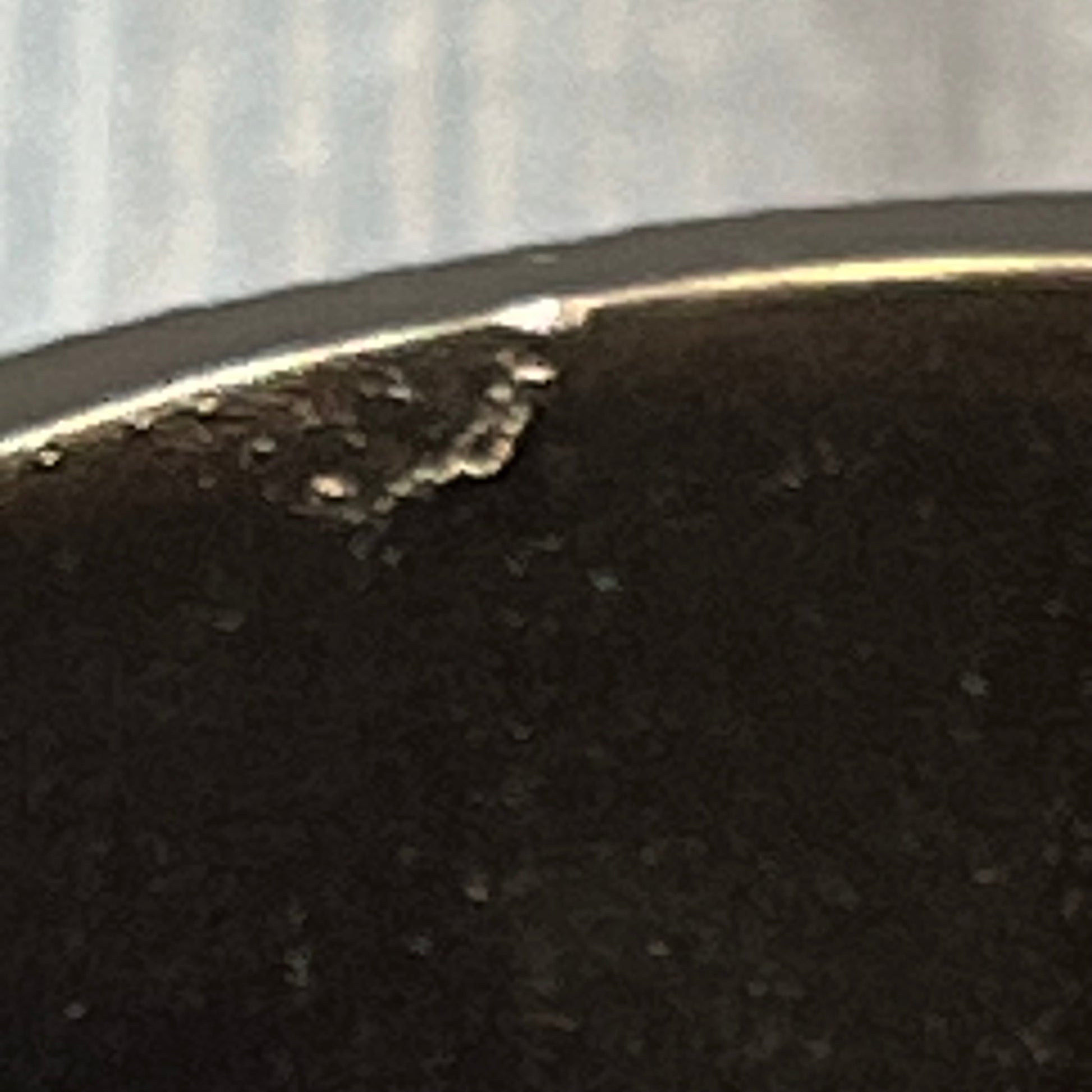 Close-up of a burgundy tumbler edge with slight imperfections, part of the Popular Bath Ombre Rose Design collection.