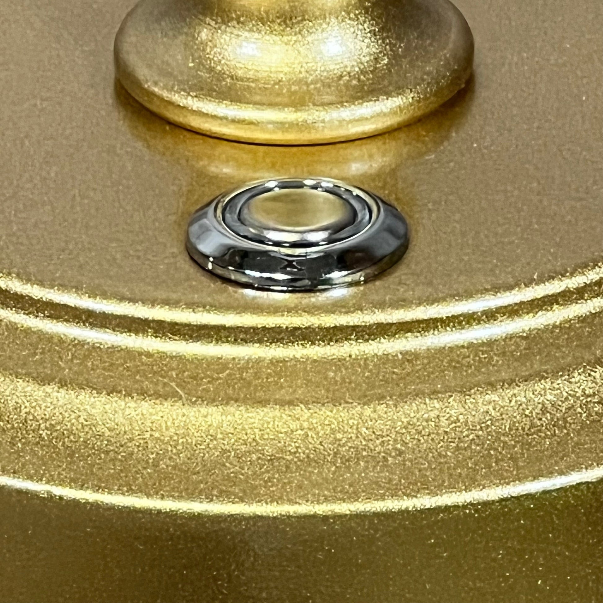 Close-up of gold rechargeable table lamp base with touch control button, featuring sleek metallic finish for modern decor.