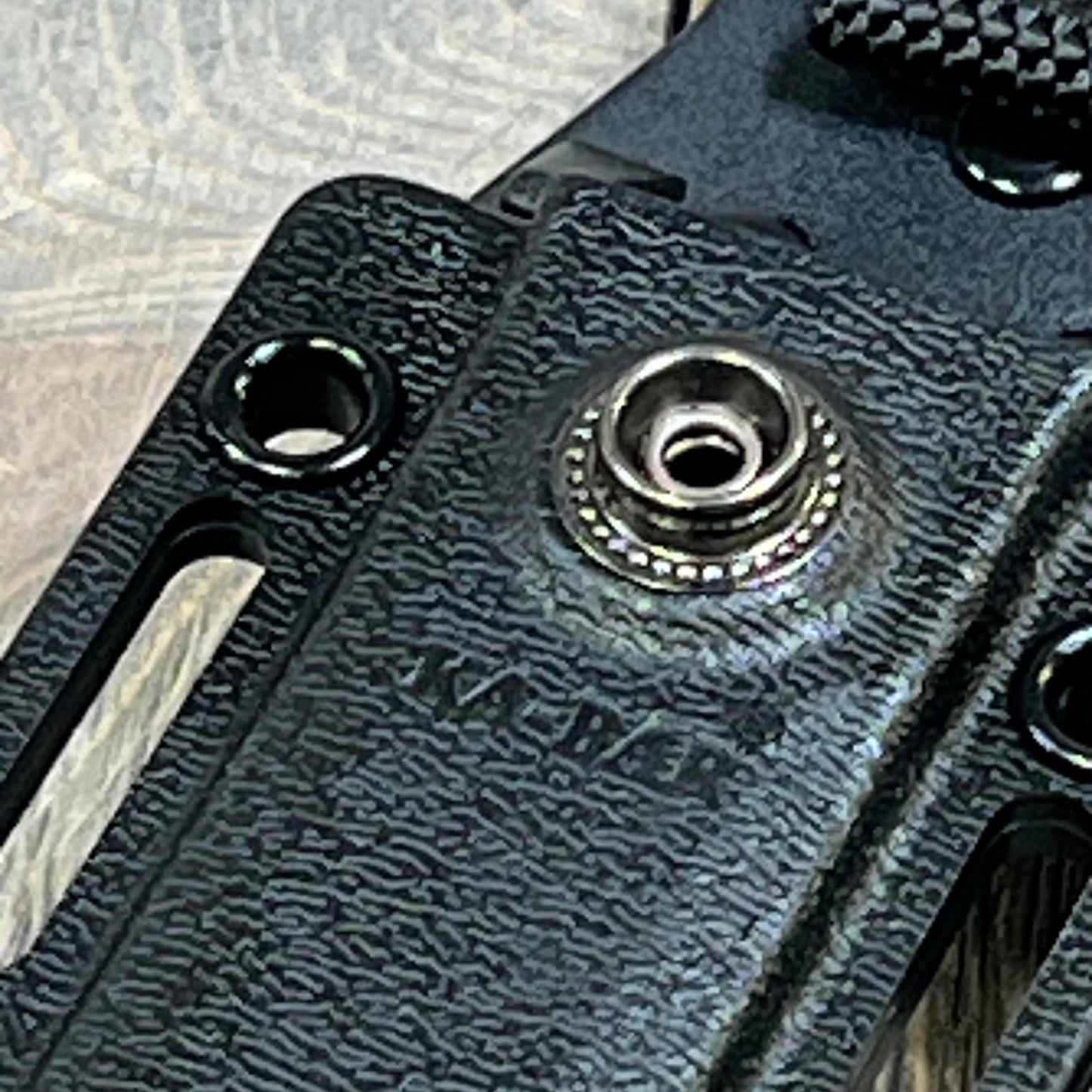 Close-up of Ka-Bar Kydex Sheath for Short, Black, showing textured design and durable rivet detail.