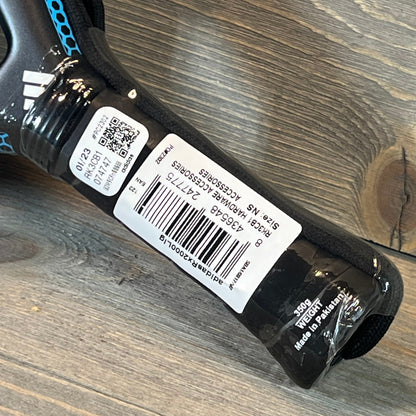 Close-up of Adidas Rx 2000 Light Padel Racket handle showing barcode and product details on a wooden surface.