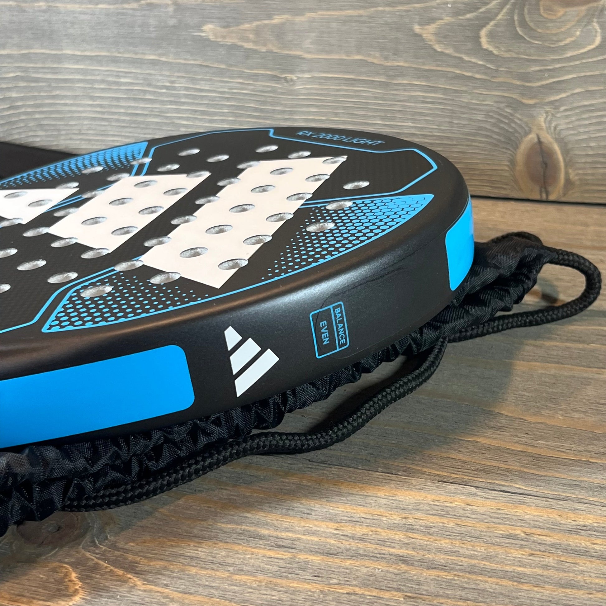 Close-up of blue Adidas Rx 2000 Light padel racket, showcasing balance and precision design.