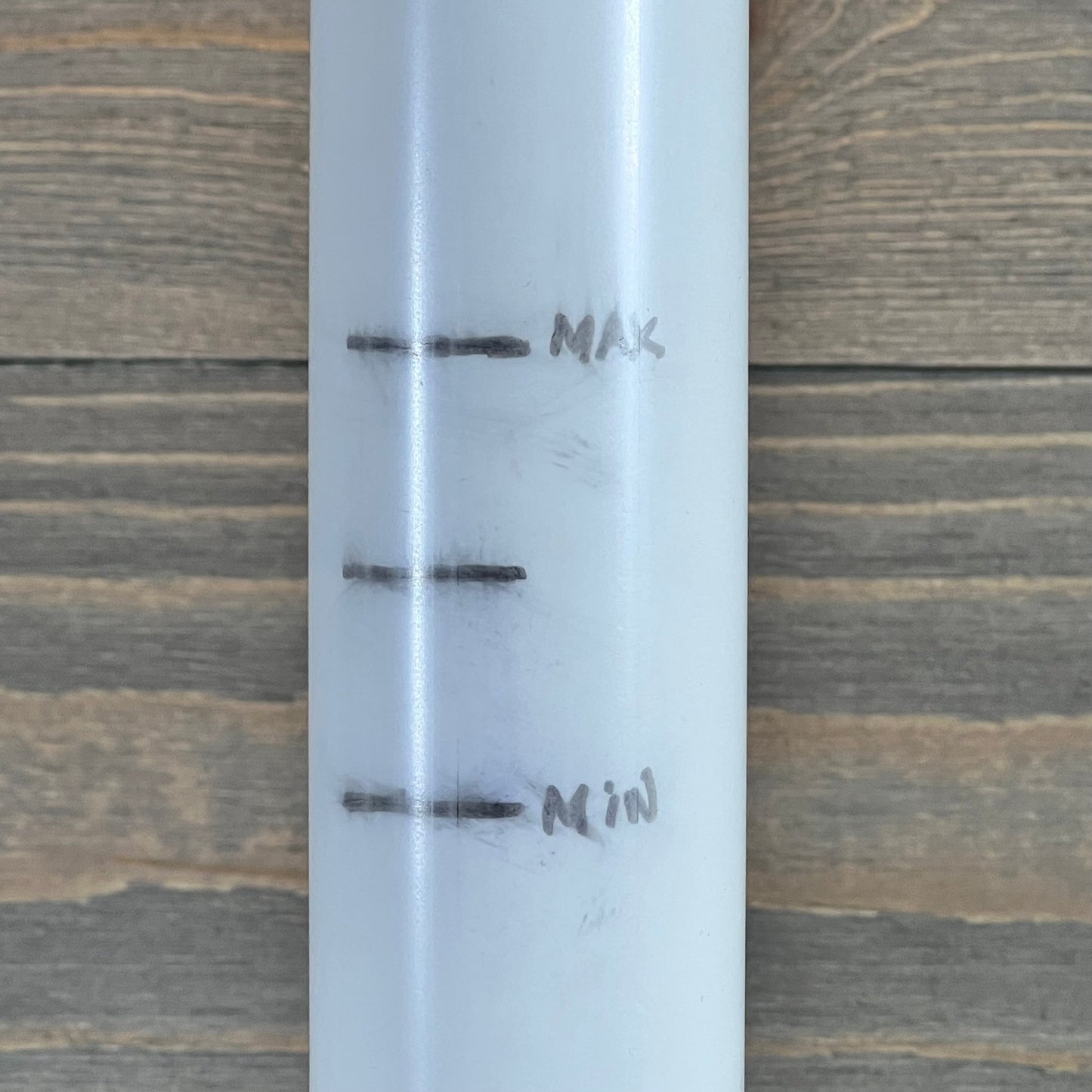 Close-up of center pipe with max and min markings for 1046029510-TIROAR SX210DA Lateral Assembly.