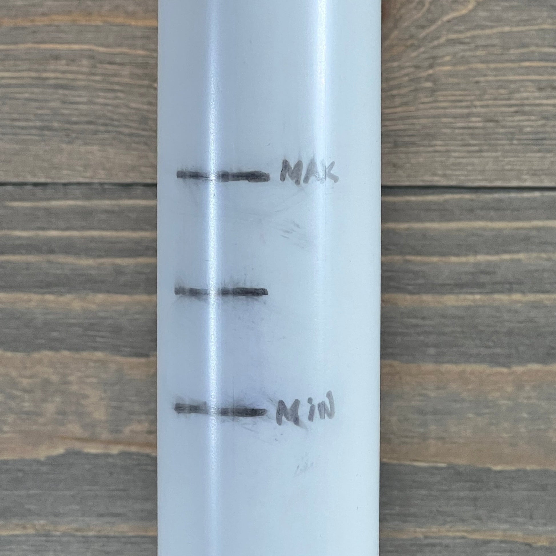 Close-up of center pipe with max and min markings for 1046029510-TIROAR SX210DA Lateral Assembly.