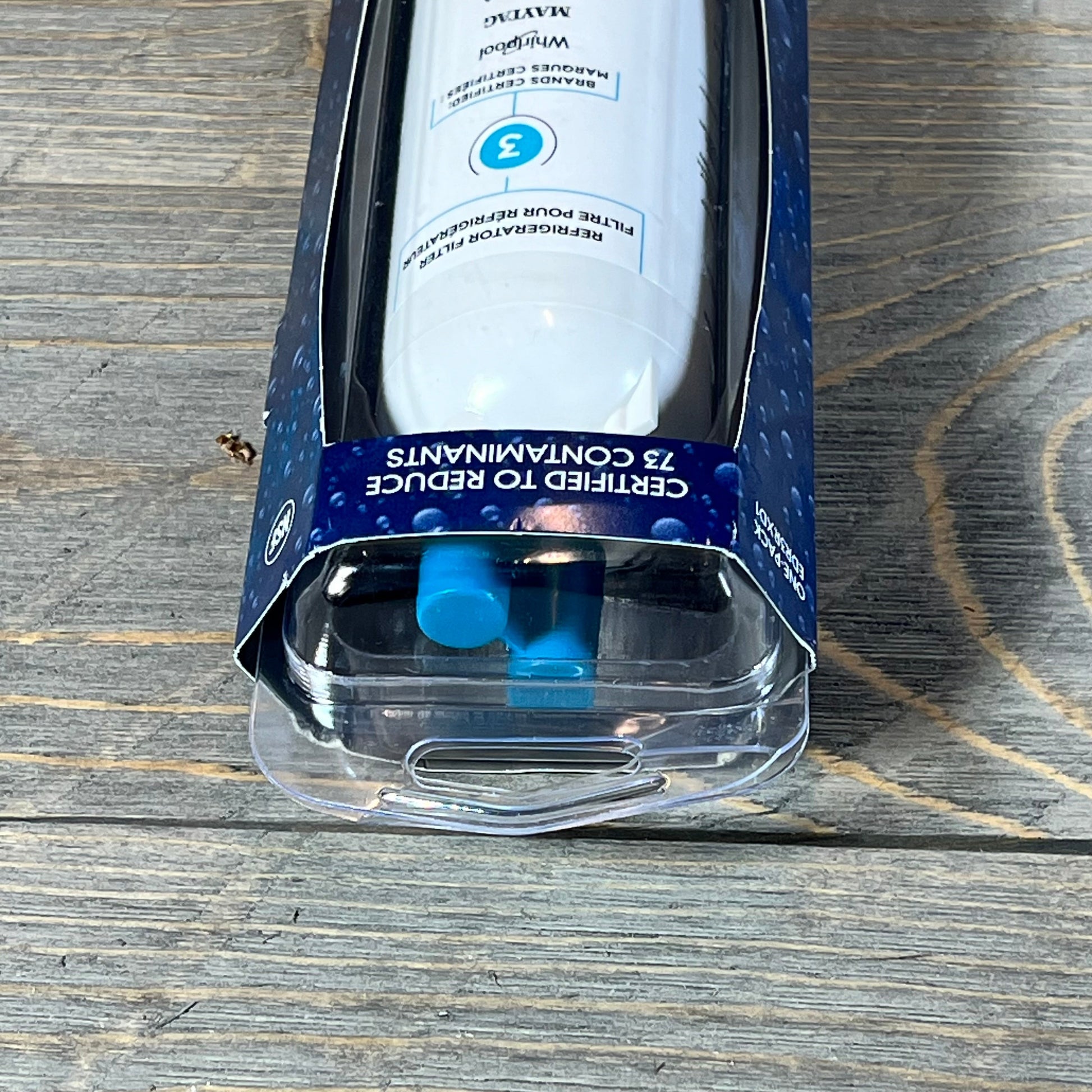 Close-up of everydrop® by Whirlpool Ice and Water Refrigerator Filter 3 in packaging on a wooden surface.