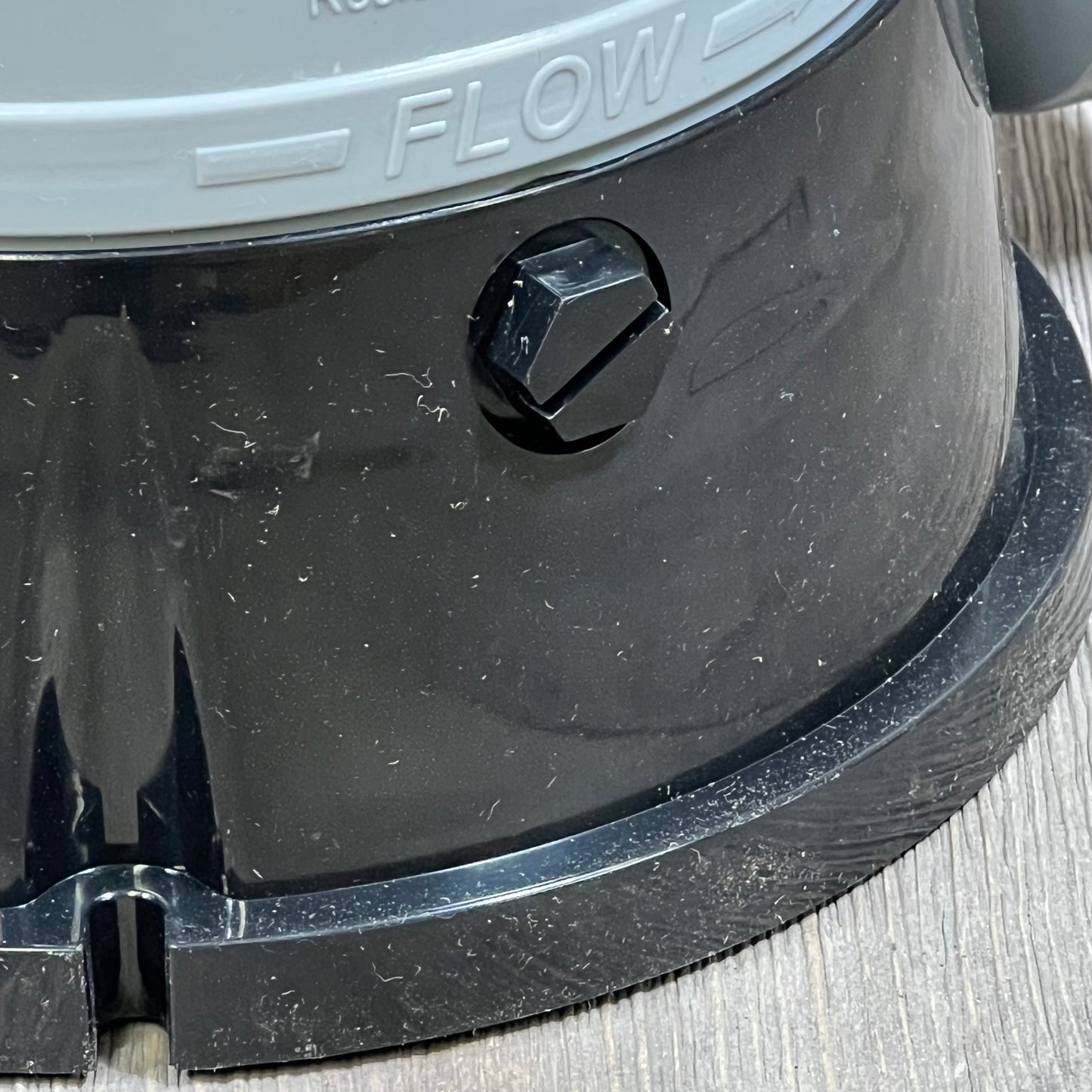 Close-up of Hayward CL200 chlorinator base showing flow direction and durable ABS material.