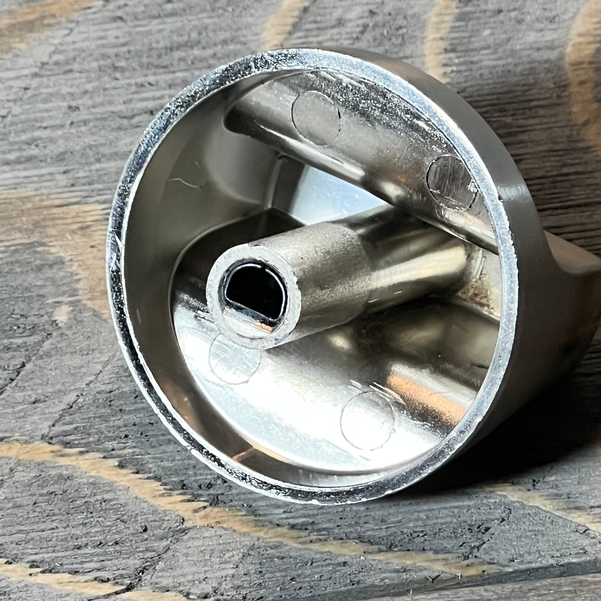Close-up of stainless steel knob for Whirlpool gas range, highlighting inner design and durability features.