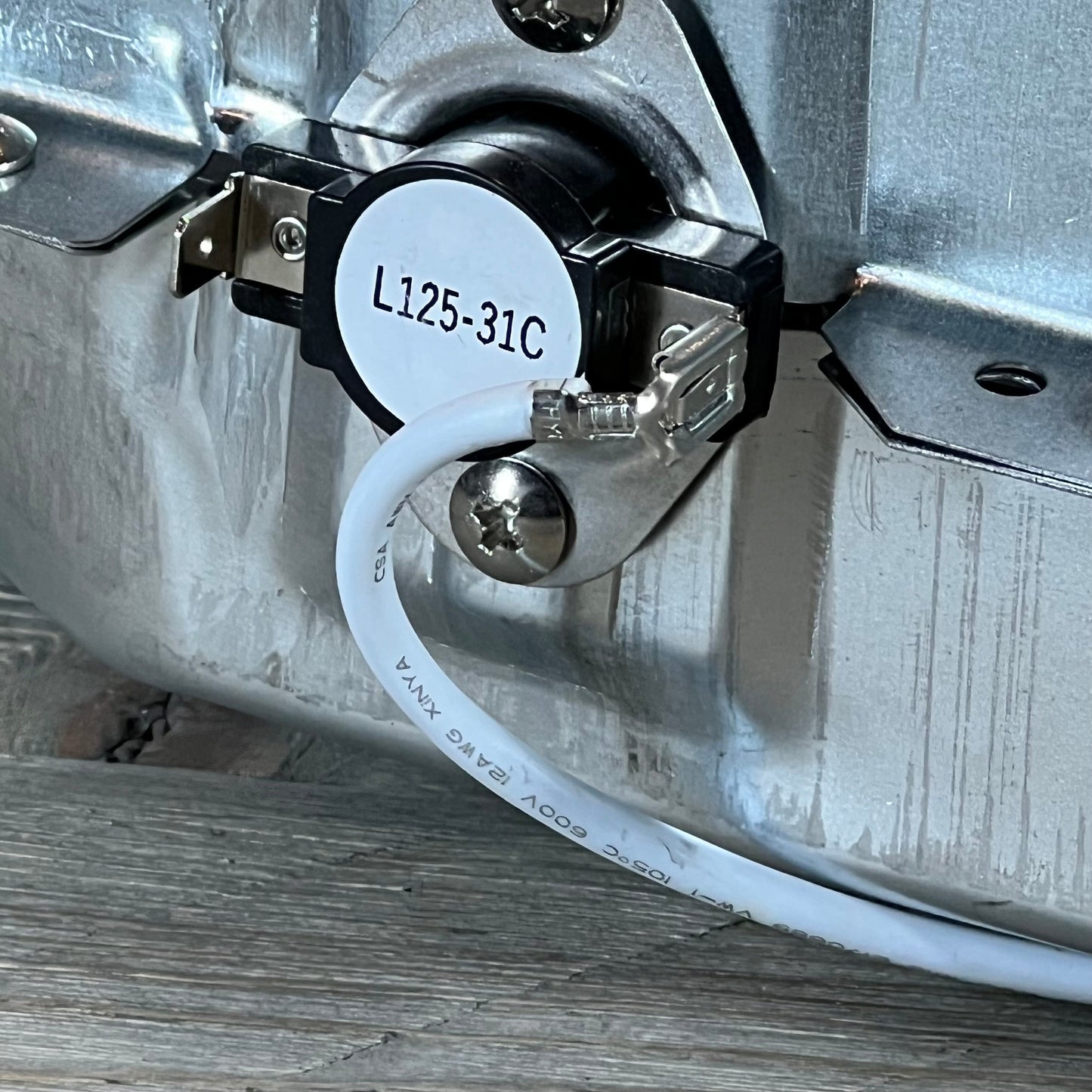 Close-up of the 1048541548-5301EL1001H dryer heating element with visible wiring and thermostat connection.