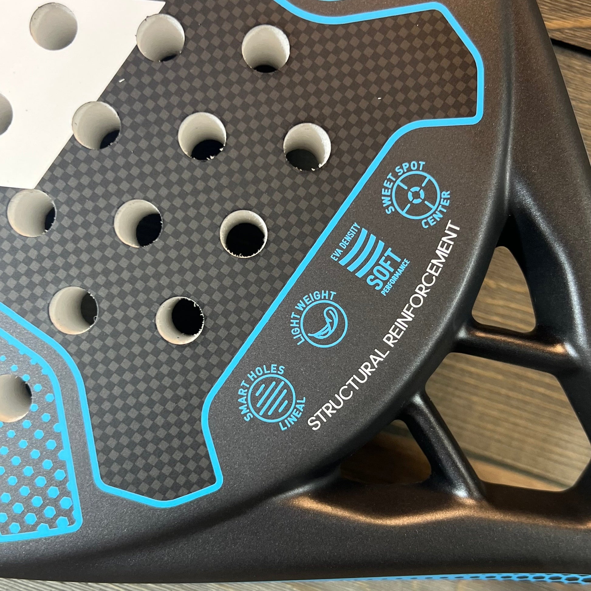 Close-up of the Adidas RX 2000 Light padel racket, showcasing its smart hole design and structural reinforcement.