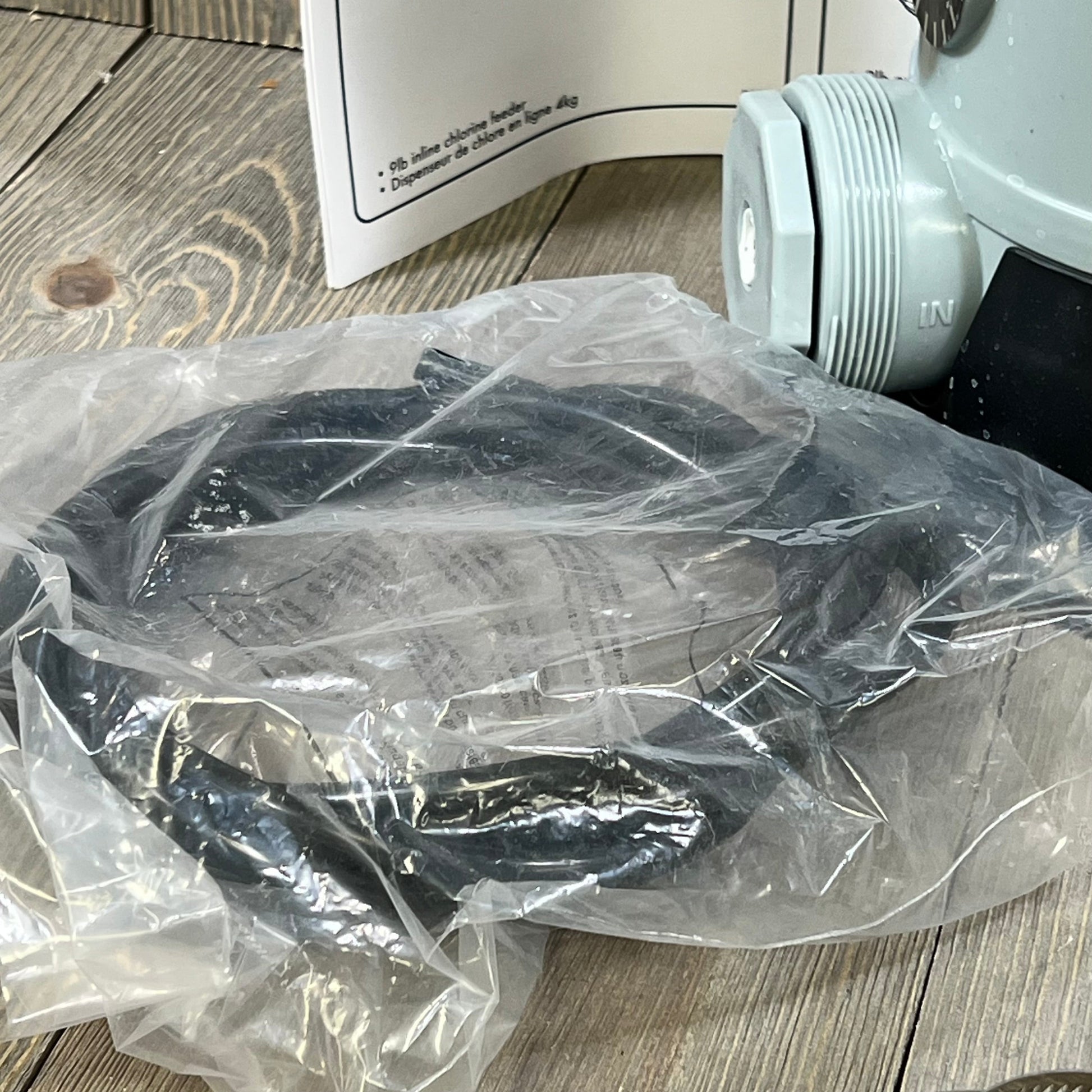 Close-up of the CL220 Automatic Chlorinator feeder components, including hoses and fittings, for pool maintenance.