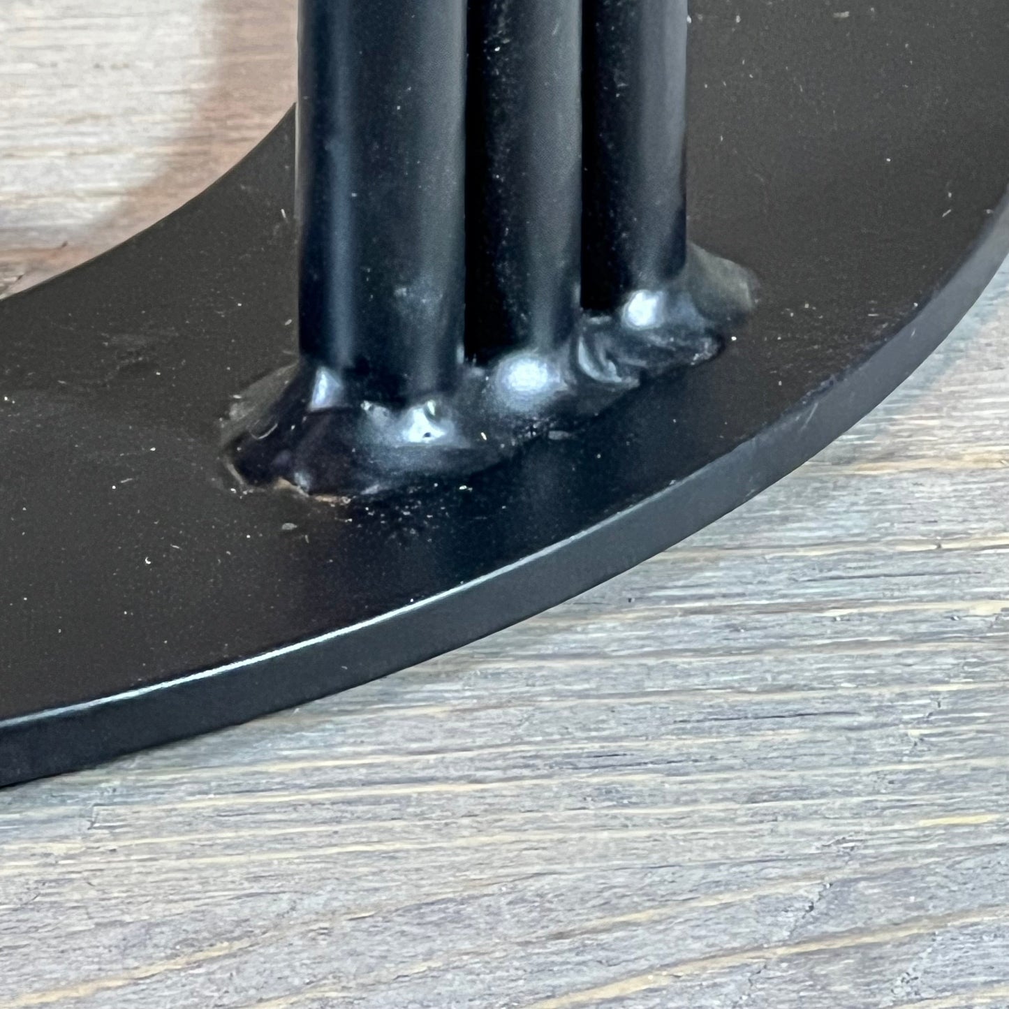 Close-up of the durable metal base of the 1048539768 wood splitter wedge resting on a wooden surface.