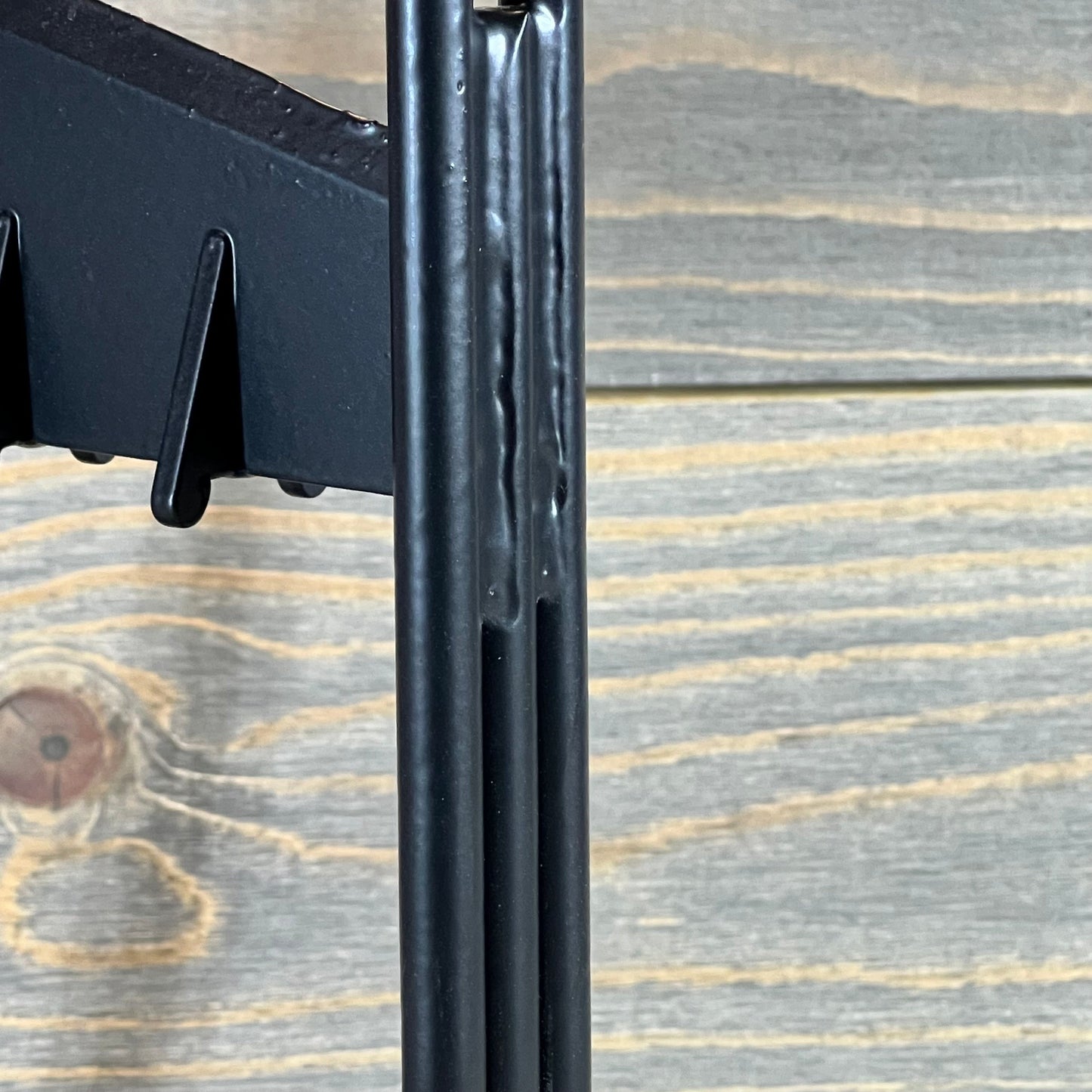 Close-up view of a manual wood splitter wedge against a wooden background, highlighting its robust metal construction.