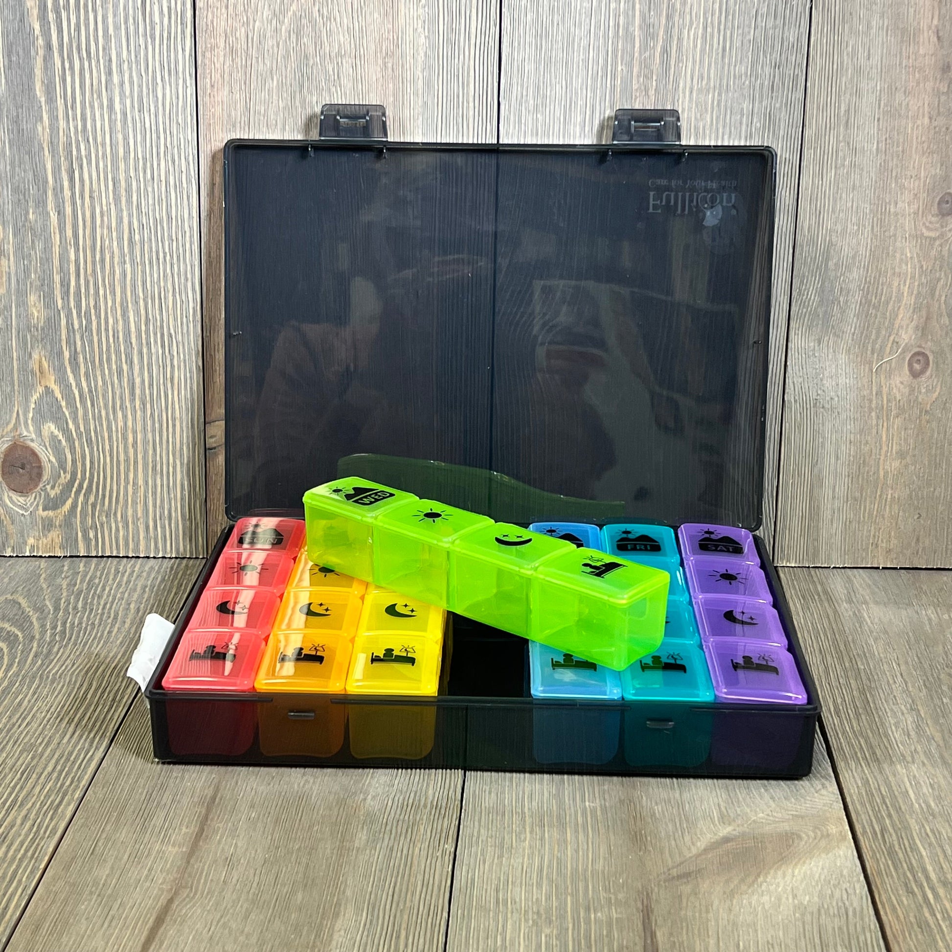 Extra large weekly pill organizer with colorful compartments for vitamins and supplements, featuring a sleek black case.