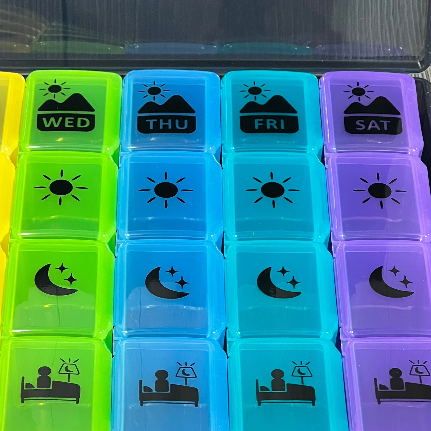 Colorful extra-large weekly pill organizer with four compartments for each day, ideal for vitamins and supplements.