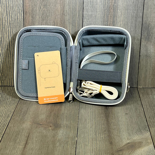 Beige K&F Concept camera case open, showing interior compartments and included straps, ideal for small digital cameras.