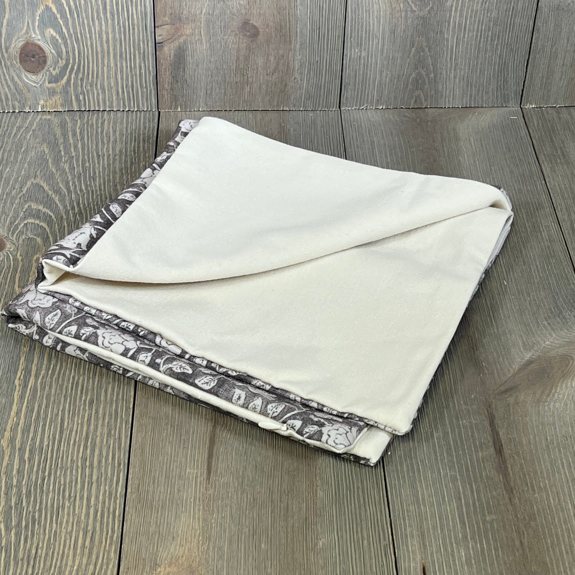 Folded DOMVITUS floral pillow cover in taupe, showcasing elegant floral print, perfect for adding a neutral accent to your couch.