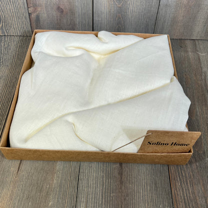 Ivory linen sheer curtain neatly folded in a box, showcasing its light-filtering fabric and elegant texture.